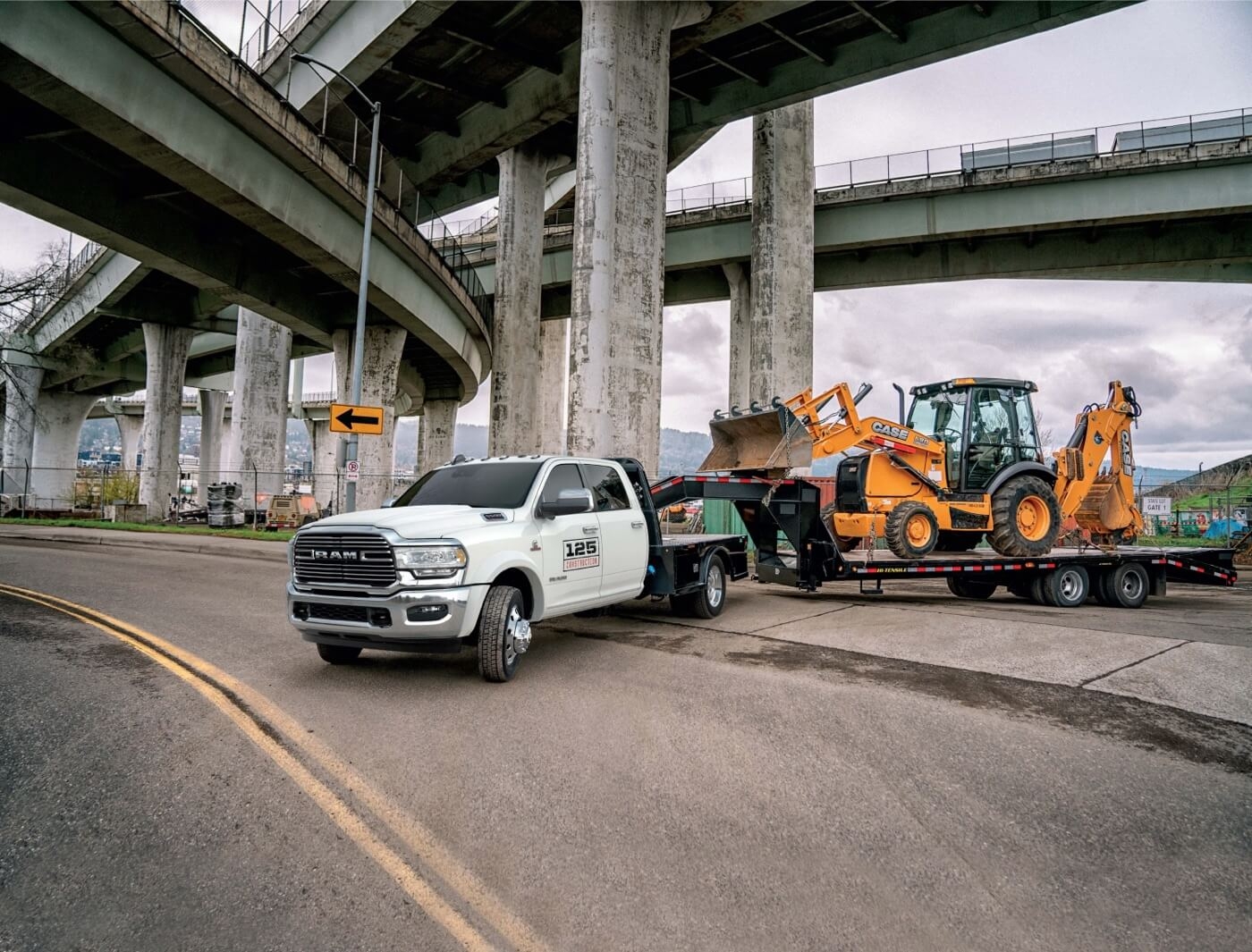 The Ram 5500 2024 chassis-cab towing a truck loader.