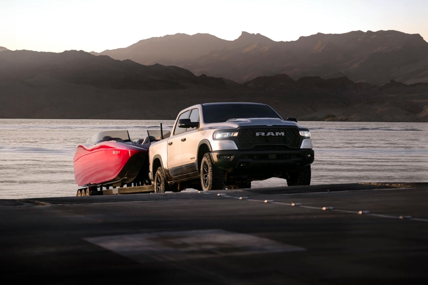 The RAM 1500 2025 towing a boat by the lake.