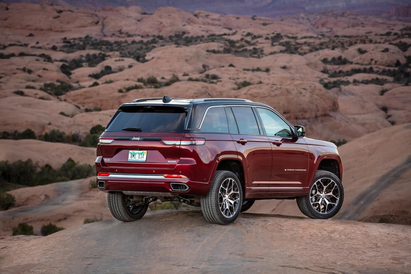 Back 3/4 view of the 2025 Jeep Grand Cherokee parked on a hill in a desert.