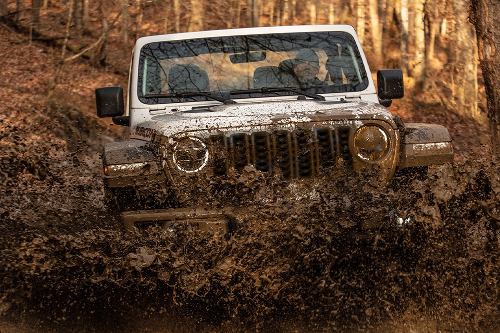 Vue avant du Jeep Wrangler 2024 traversant une marre de boue